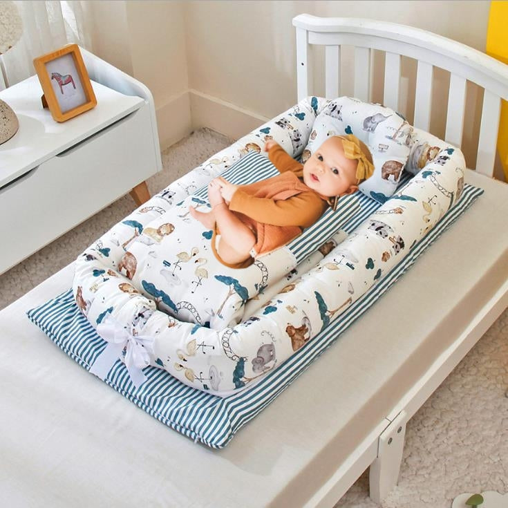 Portable baby nest with white-blue animal print mattress and fitted pillow set