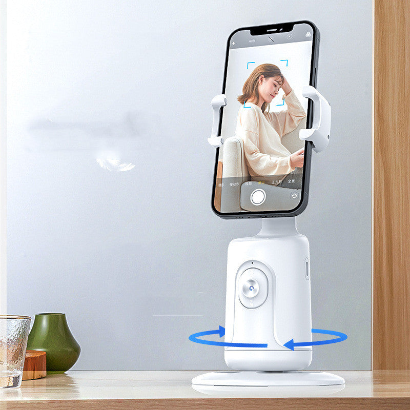 White phone stand with smartphone displaying a woman on a video call, placed on a wooden surface.