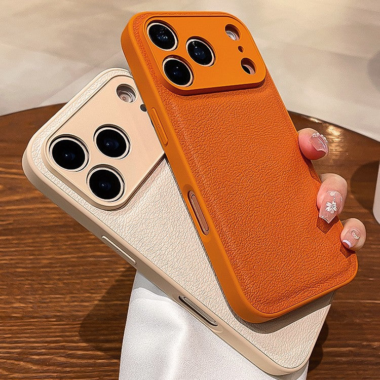Two phone cases, one orange and one beige, held by a hand on a wooden surface.