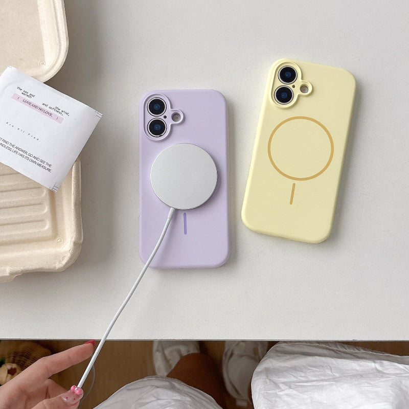 Two phone cases, one purple and one yellow, with a charging cable on a white surface.
