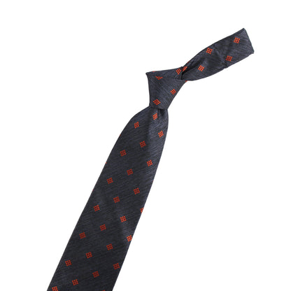 Black tie with red pattern and two decorative pins on a white background