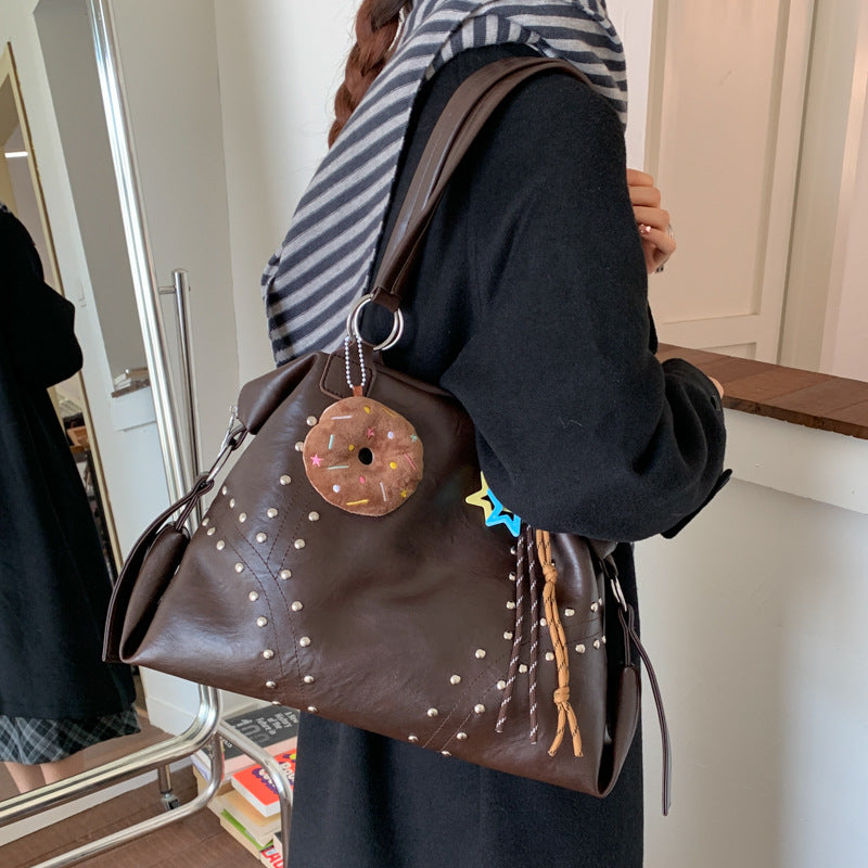 Women's shoulder bag, dark brown with studded accents, donut keychain and star charm