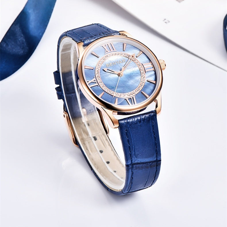 Rose gold-tone quartz watch with blue leather strap and round light dial with Roman numerals