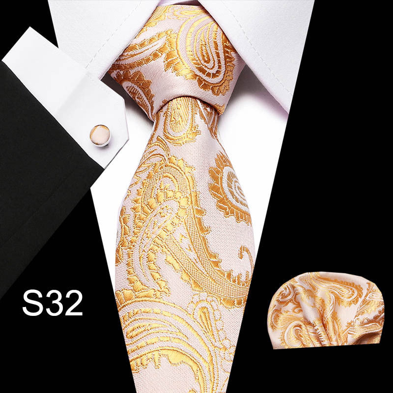 Men's business tie with gold paisley pattern on a light background