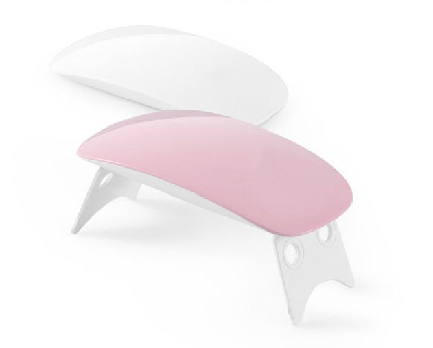 Pink portable USB LED nail lamp with matching white base and curved top
