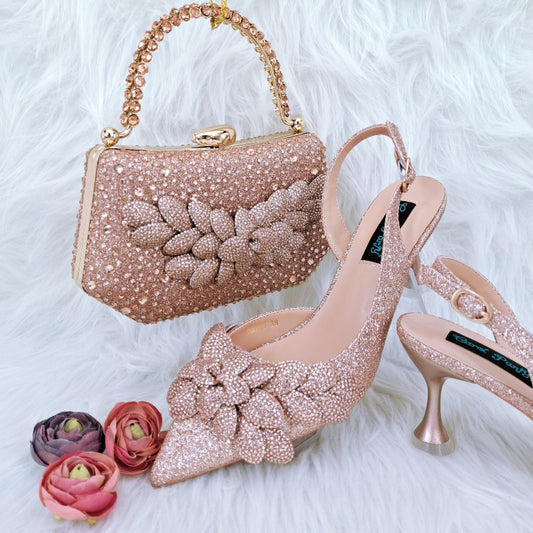 Rose gold handbag and high-heeled shoes with floral details on a white fur background