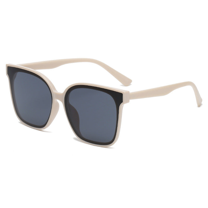 Beige sunglasses with dark lenses on a white background