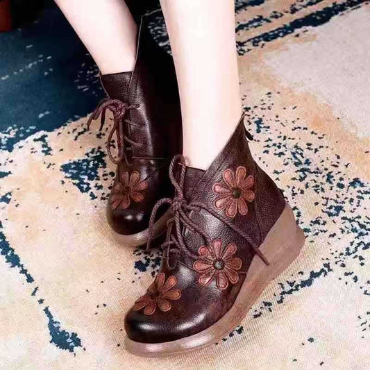 Brown leather boots with floral designs on a patterned rug