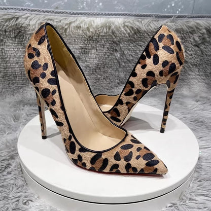 Leopard print high-heeled shoes on a white platform with a gray textured background