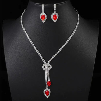 Jewelry set with necklace and earrings featuring red heart-shaped stones on a black background