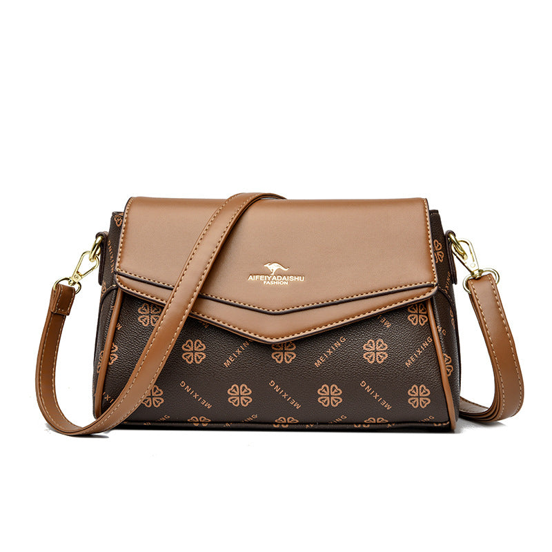 Dark brown patterned crossbody shoulder bag with tan flap and gold-tone hardware, wide strap
