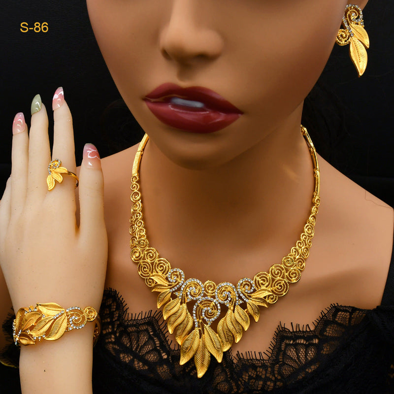 Mannequin wearing gold jewelry including a necklace, ring, and bracelet on a black background.
