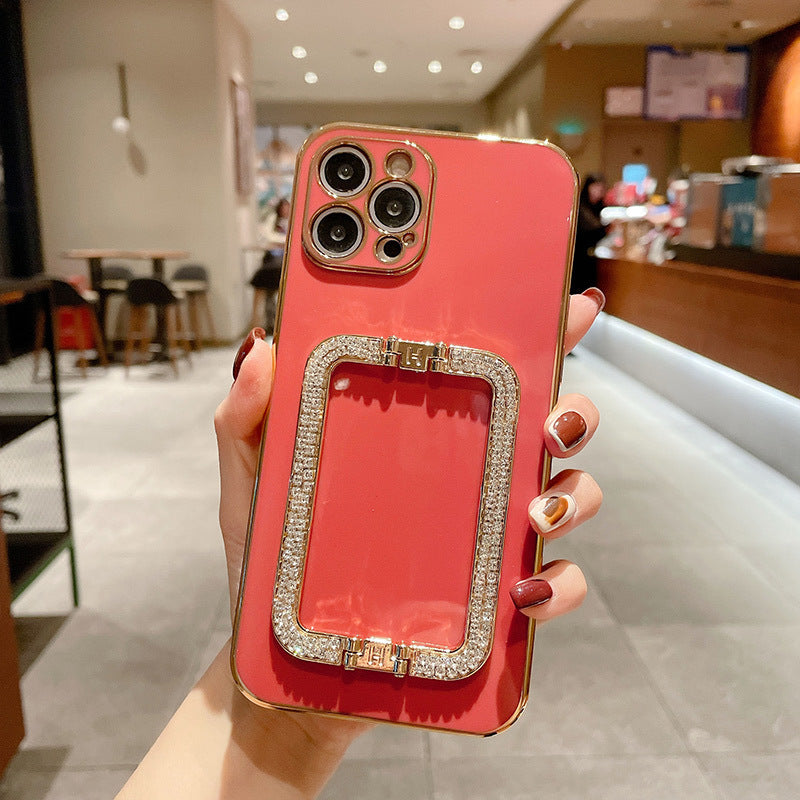 Person holding a red phone case with a decorative border in an indoor setting