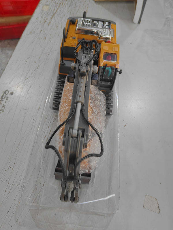 Yellow and gray RC excavator toy underside with tracks, in clear plastic wrap