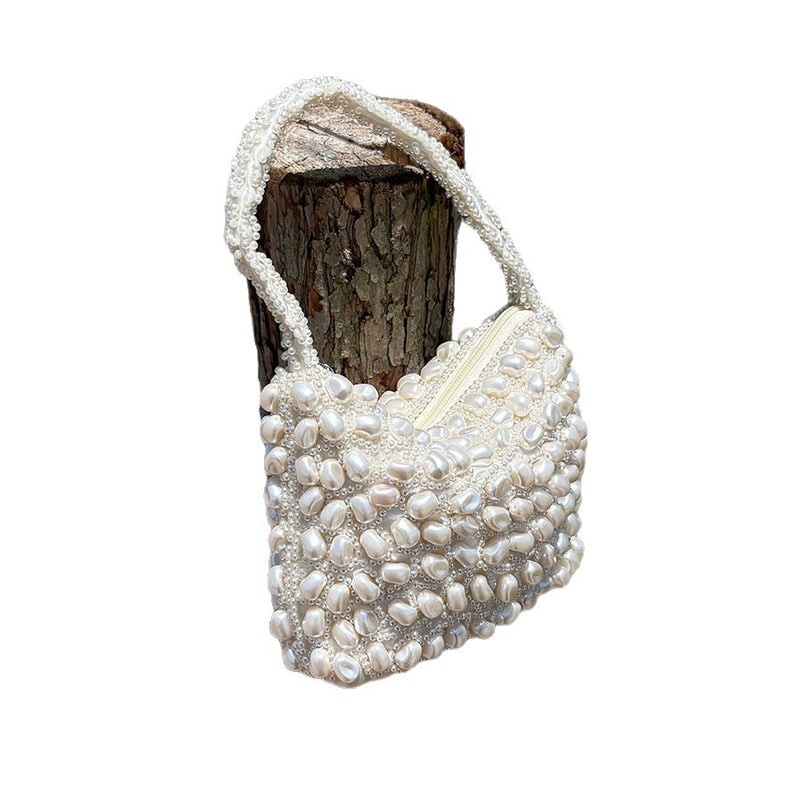 White pearl-beaded woven handbag with open top, structured beadwork and top handle
