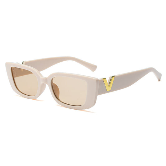 Beige sunglasses with a gold 'V' on a white background