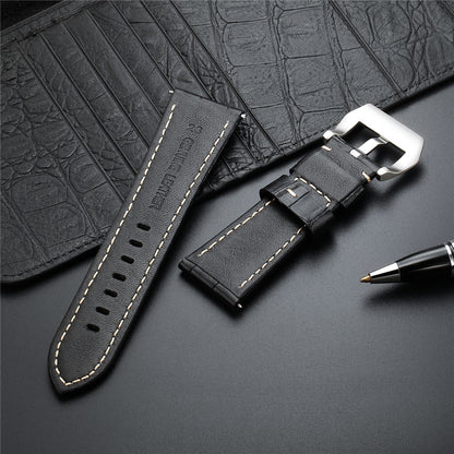 Black leather watch strap with metal buckle, perforations, and tan stitching.