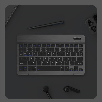 Black keyboard on a dark surface with a pen and earbuds.