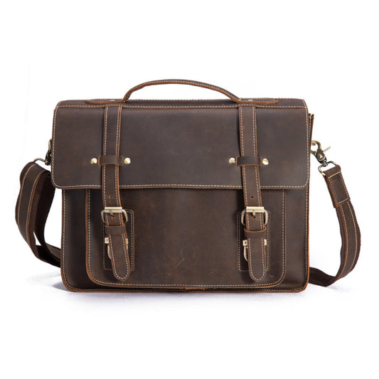 Brown leather briefcase with shoulder strap on a white background