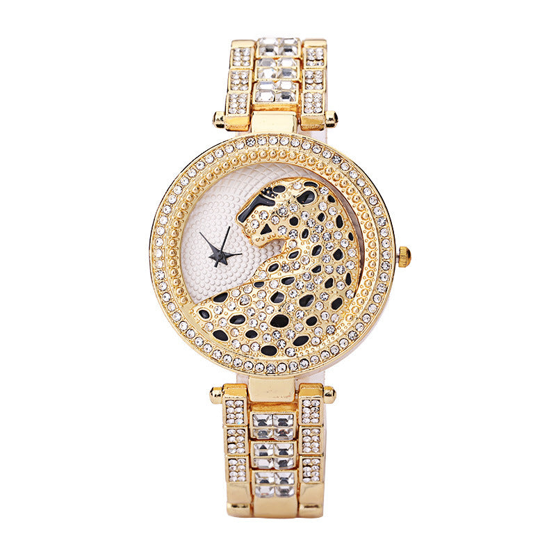 Gold wristwatch with decorative face and crystals on a white background