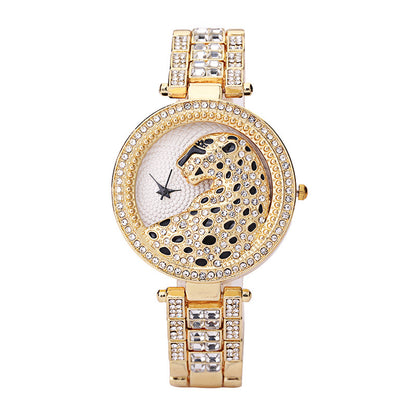 Gold wristwatch with decorative face and crystals on a white background