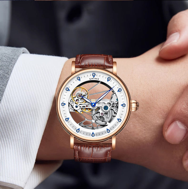 Gold-tone skeleton automatic watch with brown leather strap, blue hands and markers