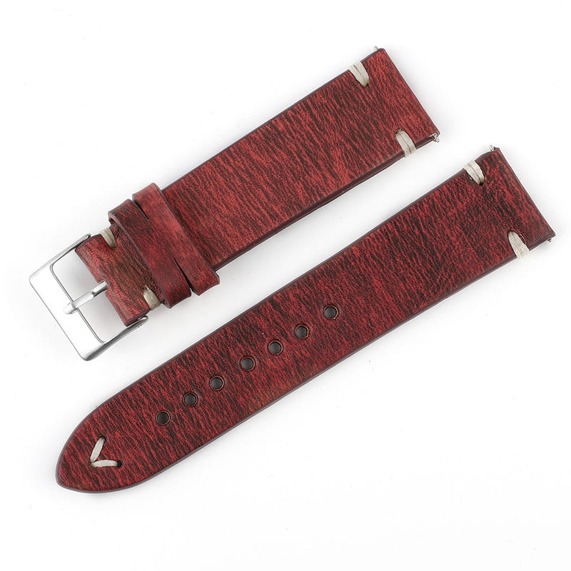 Patterned red-brown leather watch strap pair with metal buckles and punched holes