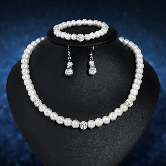 Pearl jewelry set with necklace, bracelet, and earrings on a black stand against a dark blue background.