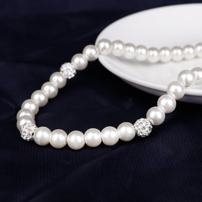 Pearl bracelet with smooth round beads and crystal accent center bead