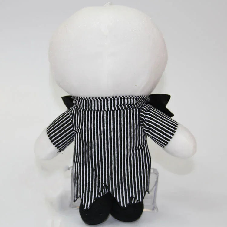 Plush stuffed doll back view with white head and black-and-white striped shirt.