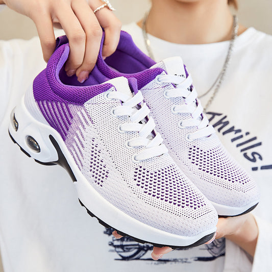 White and purple sneakers being held by a person wearing a white shirt with 'Airfills' text.