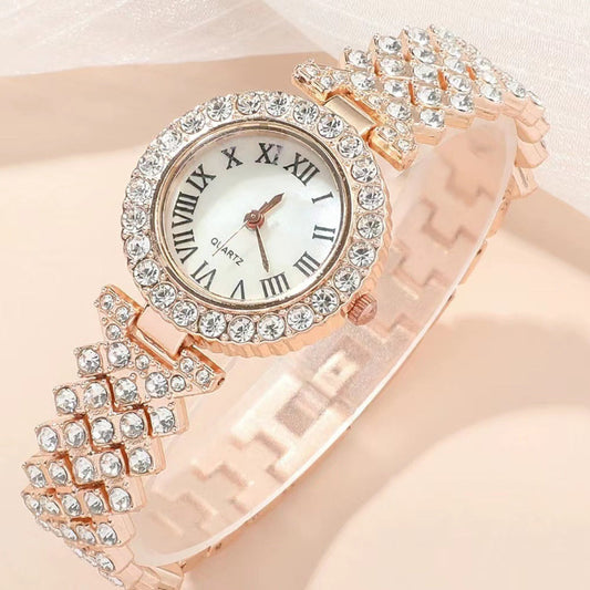Rose gold watch with diamond-studded band on a light pink background