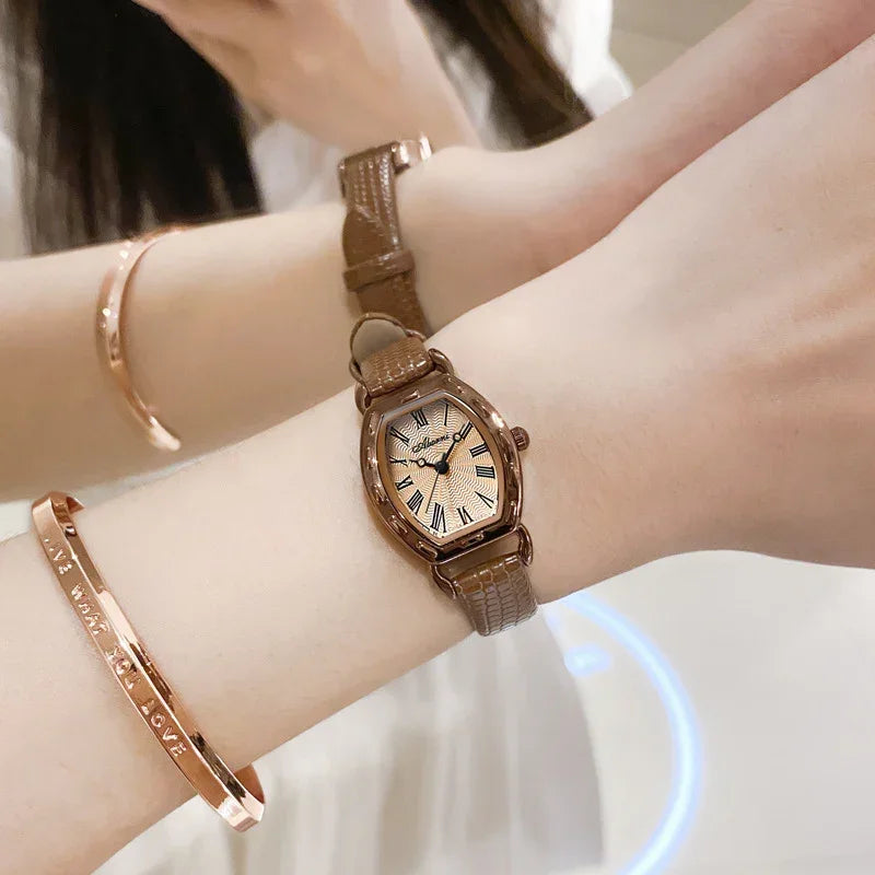 Women’s brown leather strap watch with rose gold case and Roman dial on wrist