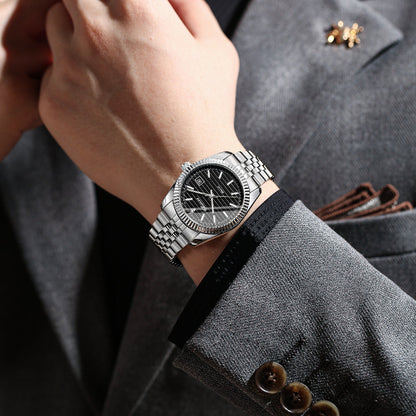 Silver watch on a person's wrist with a gray suit background