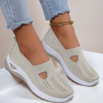 Women's Beige slip-on shoes with white soles worn by a person on a light background