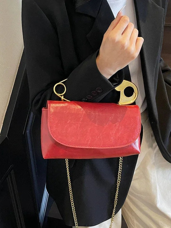 Red PU leather shoulder bag with curved clasp flap and gold chain shoulder strap