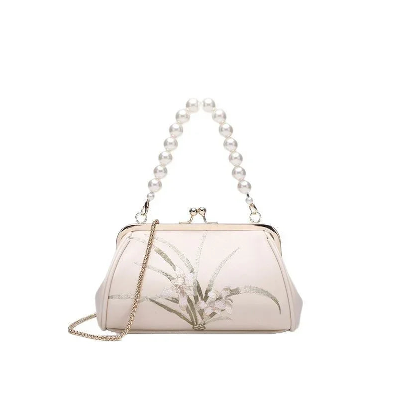 Beige embroidered shoulder bag with beaded handle, gold chain strap, and floral motif