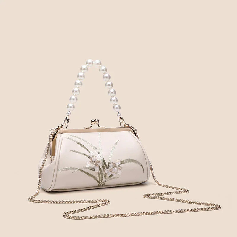 Beige embroidered shoulder bag with beaded handle and long gold chain straps