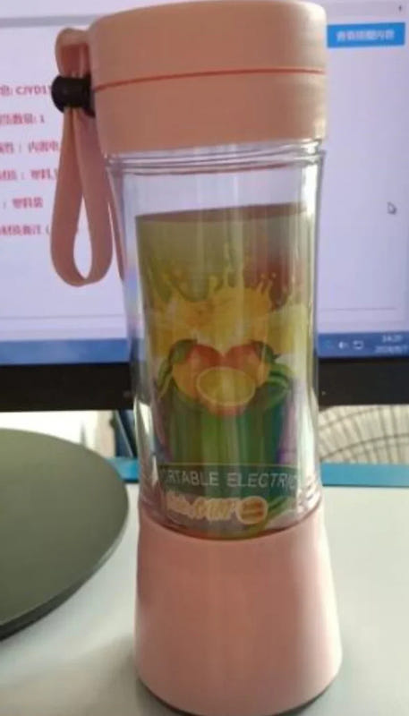 Portable USB rechargeable blender, pink with clear jar and fruit inside, wrist strap