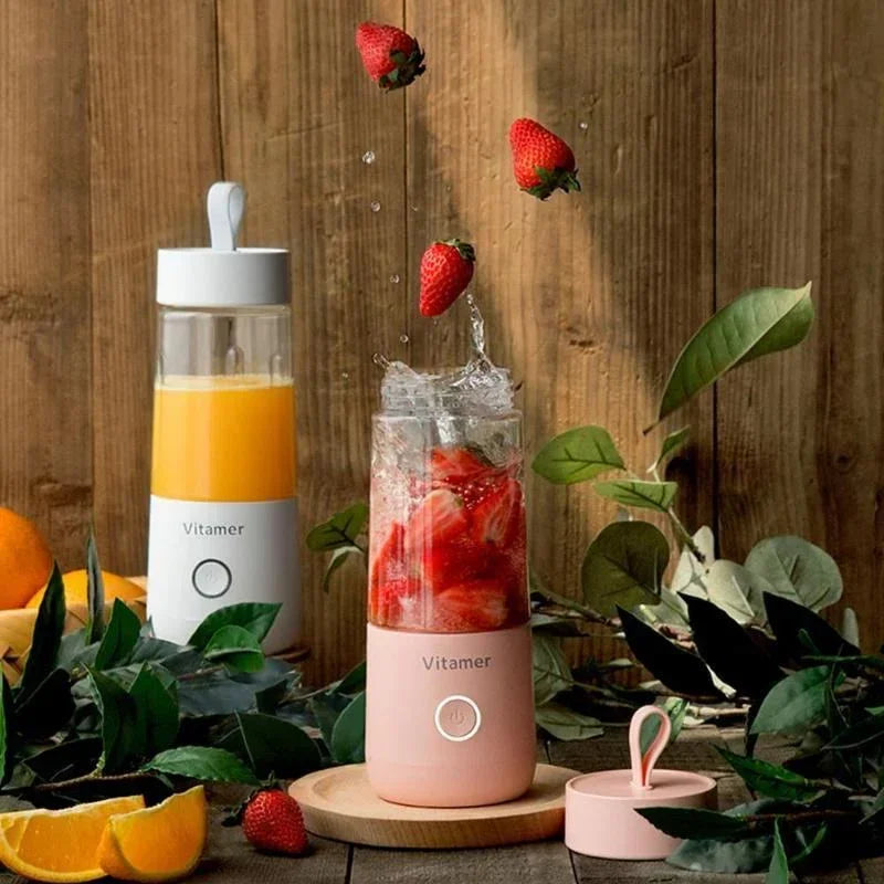 Pink portable blender bottle with clear cup, plus white bottle beside it outdoors