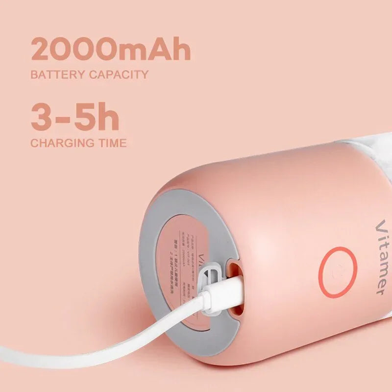 Pink portable blender showing charging cable connected to base