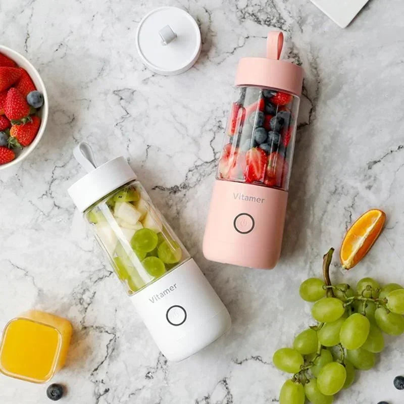 Pink and white portable blender bottles with clear cups on marble surface