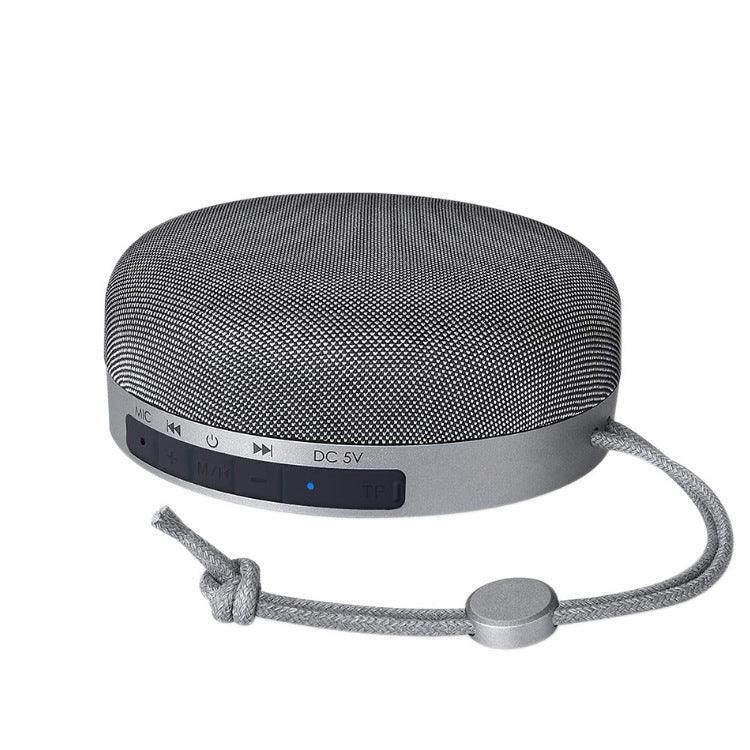 Grey cloth Bluetooth speaker with front controls and small power indicator light