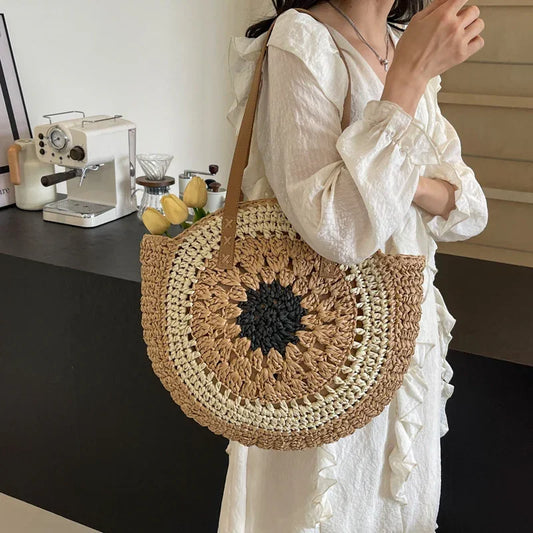 Crochet straw tote bag with dark round floral center and brown leather handles