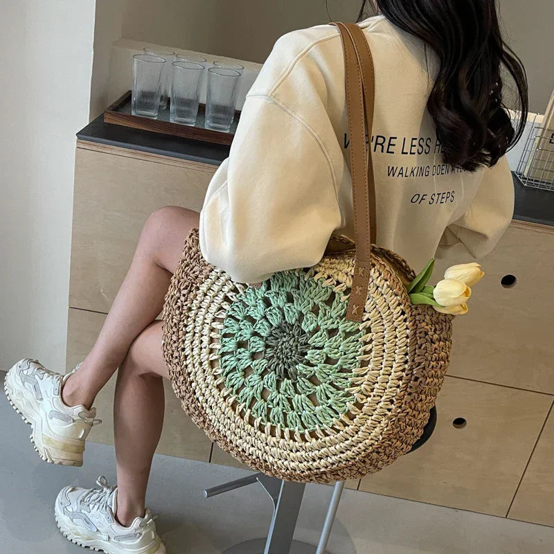 Crochet straw tote bag with green round floral center and brown leather handles