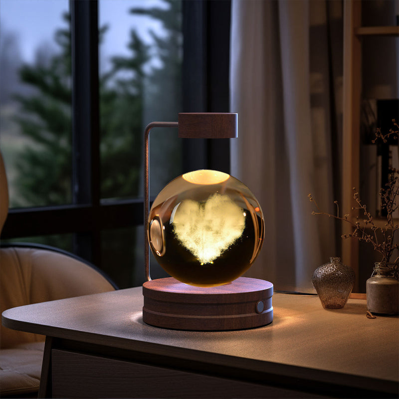 Crystal ball LED night light glowing with warm light, round wood base on tabletop