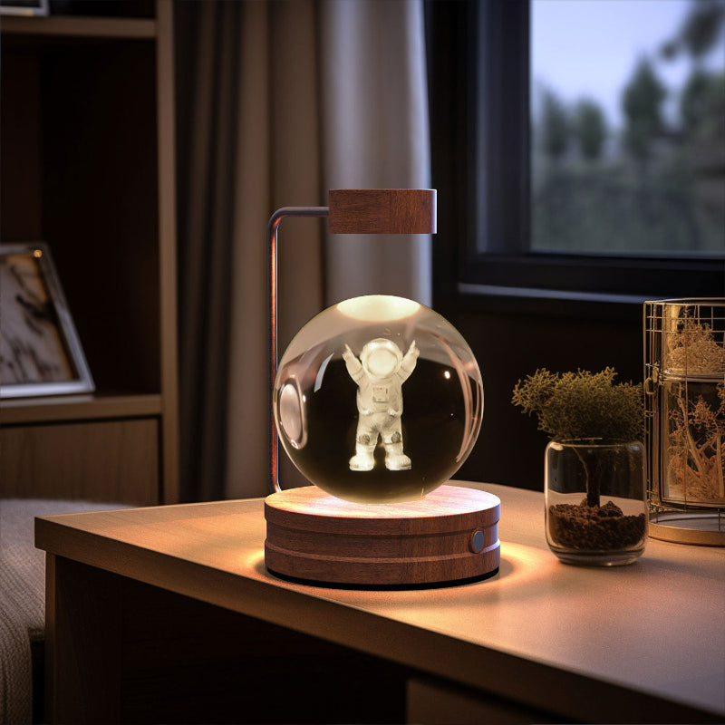 Crystal ball LED night light with astronaut figure inside clear globe, light wood base