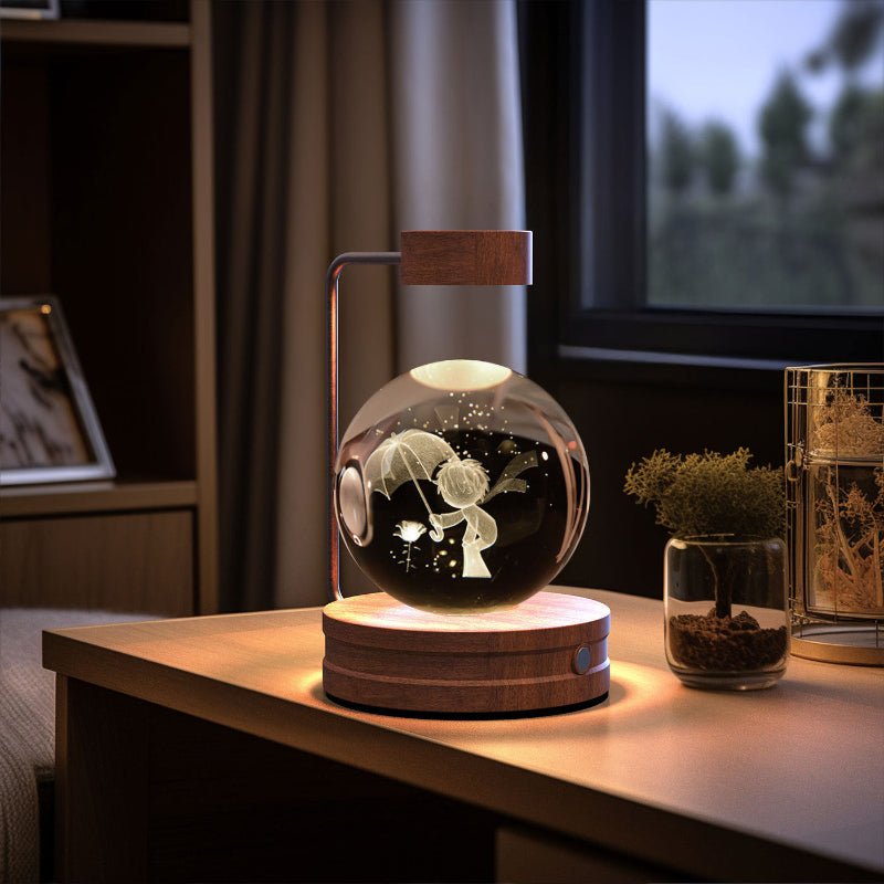 Glowing crystal-ball LED night light on round dark wood base with warm light and figure silhouette.