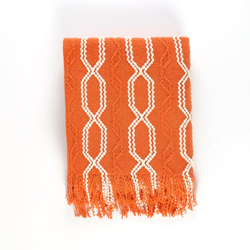 Orange throw blanket with white geometric pattern on a white background