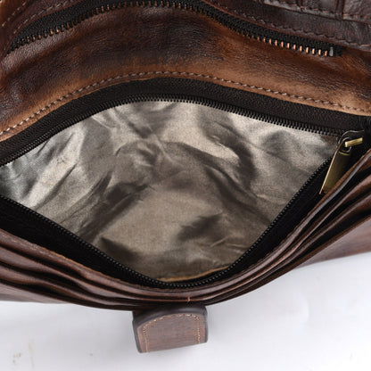 Close-up of a brown leather bag with a zipper on a white background